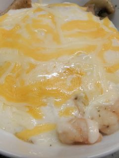 Una foto de gambas,setas y champiñones gratinados con bechamel.