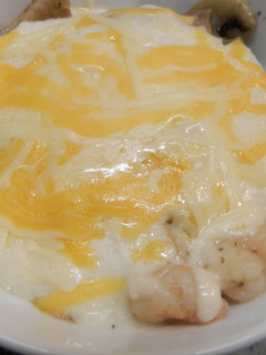 Una foto de gambas,setas y champiñones gratinados con bechamel.
