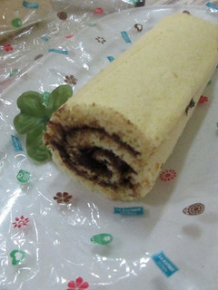 Una foto de Tronco de árbol con crema de chocolate y cerezas