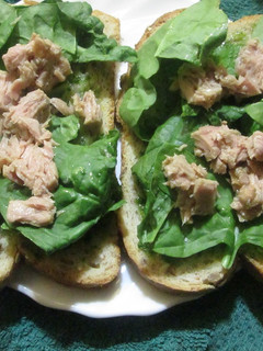Una foto de Pan blanco con salsa verde, brotes de espinaca y atún