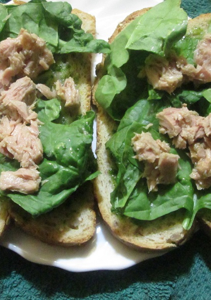 Una foto de Pan blanco con salsa verde, brotes de espinaca y atún 