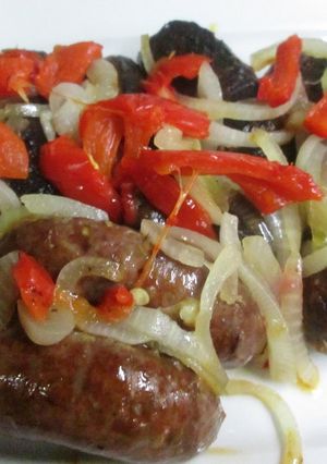 Una foto de Chorizos al horno con cebolla caramelizada y pimientos asados