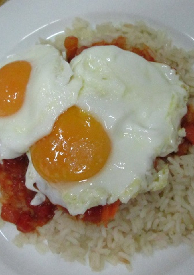 Una foto de Arroz con salchichas en salsa y huevos fritos
