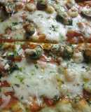 Pizza casera con mariscos y salsa verde de ajo y perejil