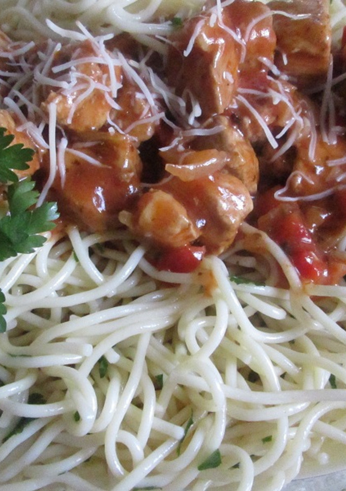 Una foto de Espaguetis al perejil con dados de cerdo en salsa de tomate