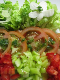 Una foto de Ensalada de tomate, lechuga y pimientos con salsa verde