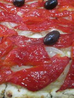 Una foto de Coca de cebolla caramelizada y pimientos asados