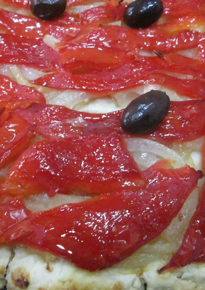 Una foto de Coca de cebolla caramelizada y pimientos asados