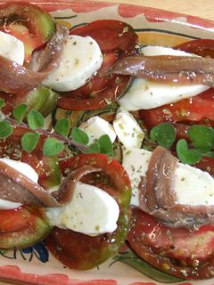 Una foto de Ensalada de tomates negros con mozzarella y anchoas