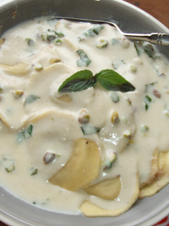 Una foto de Ravioli con salsa de queso, albahaca y pistachos