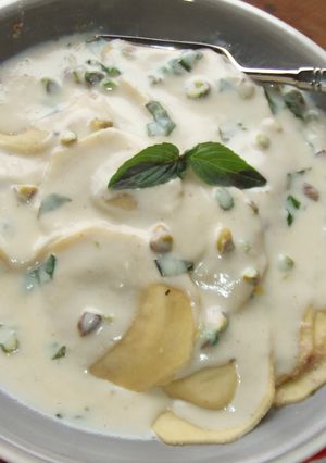 Una foto de Ravioli con salsa de queso, albahaca y pistachos