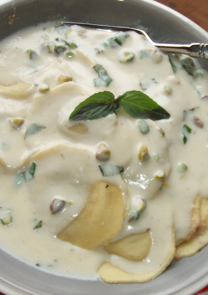 Una foto de Ravioli con salsa de queso, albahaca y pistachos