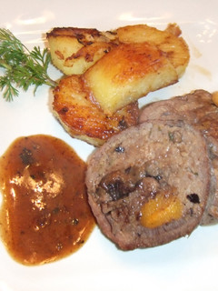 Una foto de Rollo de ternera relleno con su salsa y patatas a la inglesa