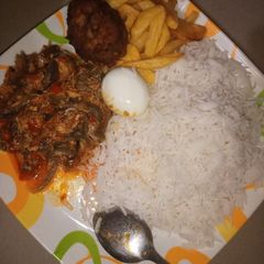 A picture of Basmati rice and fish sauce served with fried chips&boiled egg.