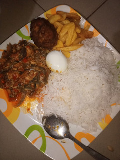 A picture of Basmati rice and fish sauce served with fried chips&boiled egg.
