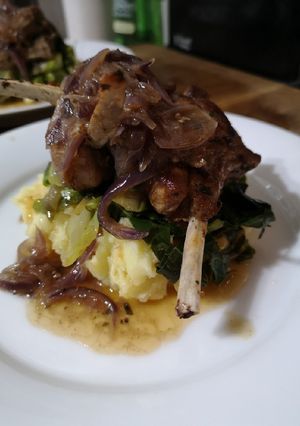 A picture of Marinaded lamb cutlets over cabbage and mash.