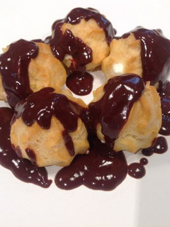 Una foto de Profiteroles de nata con chocolate caliente