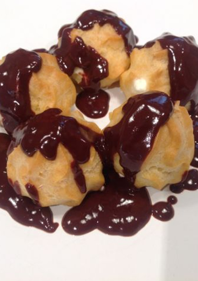 Una foto de Profiteroles de nata con chocolate caliente