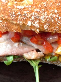 Una foto de Bocadillo de lomo ibérico con pimientos y rúcula