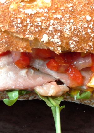 Una foto de Bocadillo de lomo ibérico con pimientos y rúcula