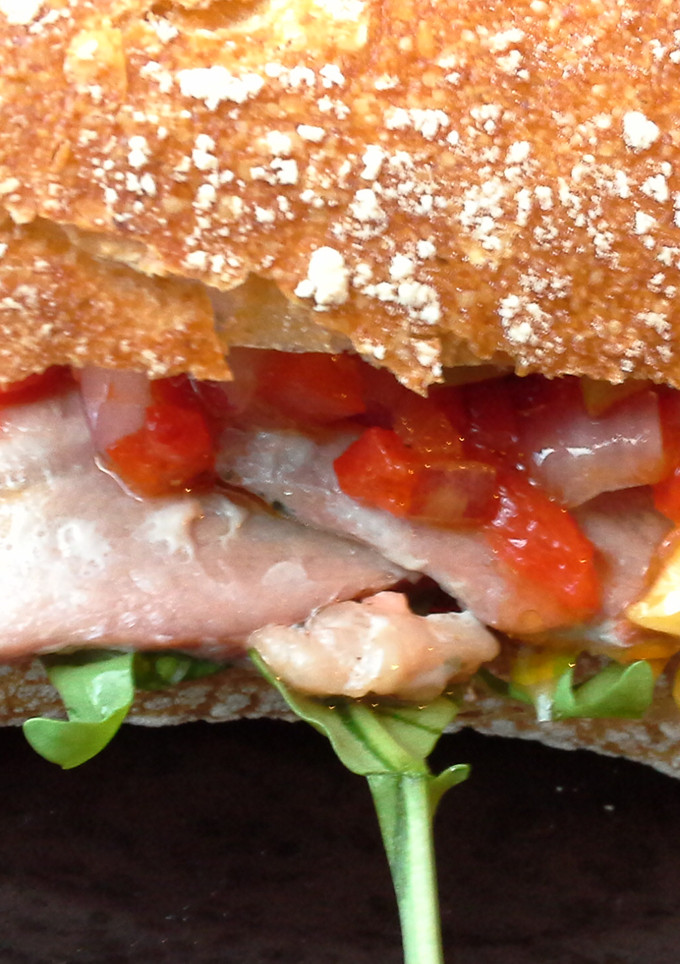 Una foto de Bocadillo de lomo ibérico con pimientos y rúcula