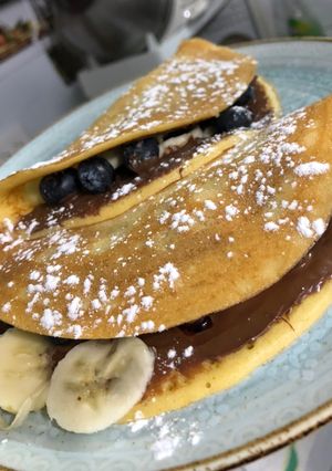 Una foto de Crepe relleno de almíbar de frutos rojos, Nutella y banano