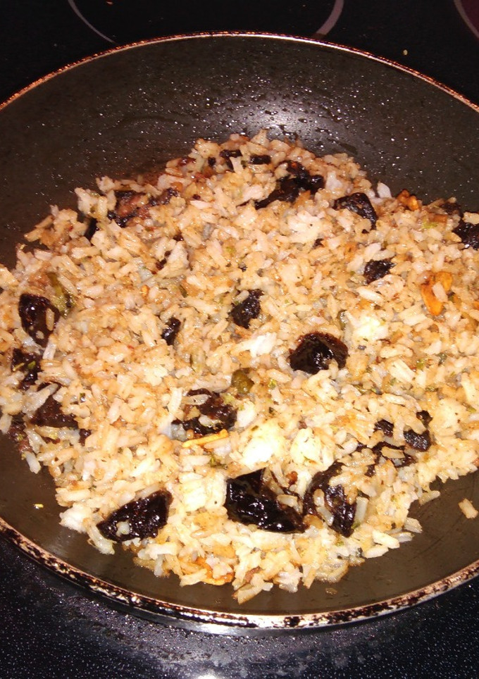 Una foto de Arroz salteado con anchoas, ciruelas secas y alcaparras