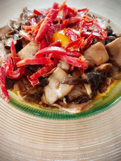 Una foto de Setas con yema curada y crujiente de jamón ibérico sobre cama de patata y calabaza