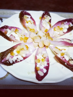 Una foto de Endivias moradas con queso Feta y cáscara de naranja confitada