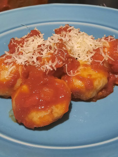 Una foto de Ñoquis de papa rellenos de brócoli y queso con salsa de tomate
