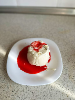 Una foto de Panna cotta de vainilla con coulis de frambuesas