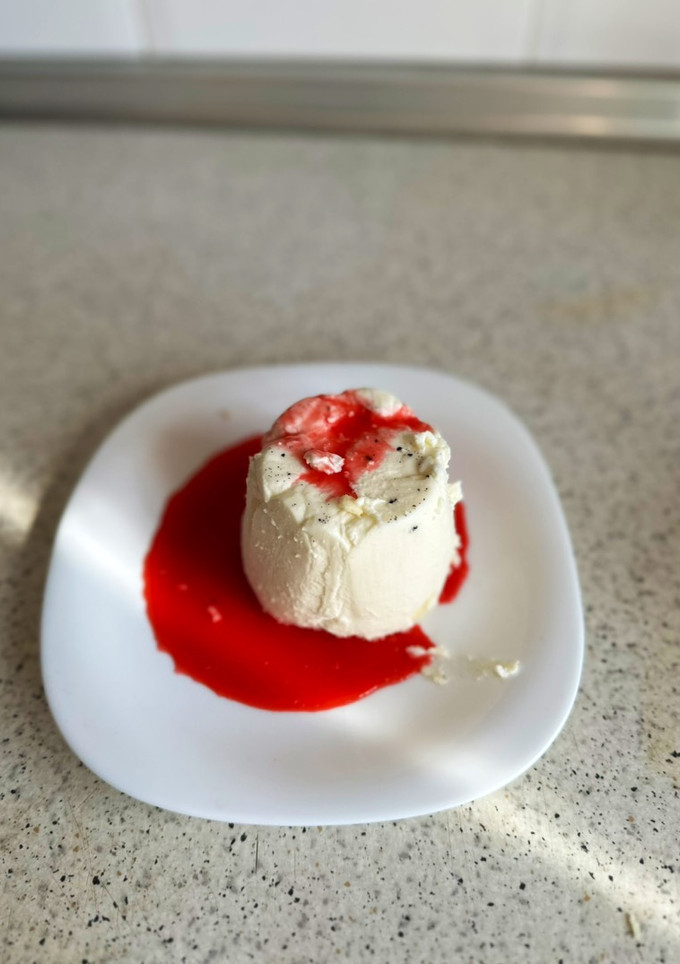 Una foto de Panna cotta de vainilla con coulis de frambuesas