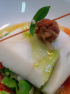 Una foto de Bacalao con tomate, ajos tiernos y cebolla confitada