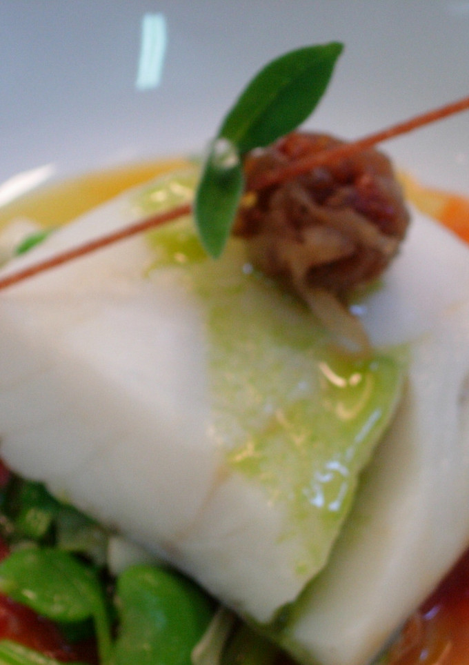 Una foto de Bacalao con tomate, ajos tiernos y cebolla confitada 