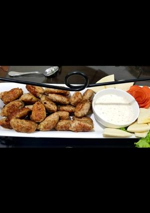 A picture of Kebabs with onion salad and spicy cream cheese sauce.