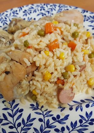 Una foto de Arroz con pollo, zanahoria, maíz, guisantes y salchicha