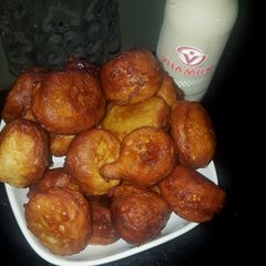 A picture of Puff puff with orange syrup.