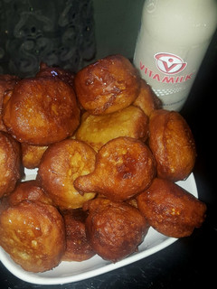 A picture of Puff puff with orange syrup.