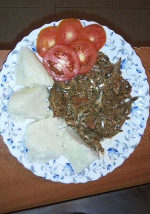 A picture of Ugali served with Omena and garnished with tomato.