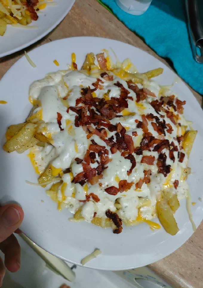 Una foto de Patatas con queso bacon y salsa ranchera