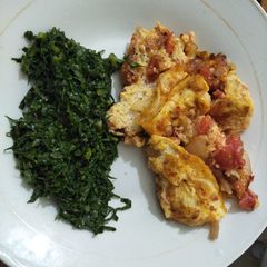 A picture of Scrambled eggs with greens.