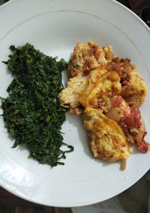 A picture of Scrambled eggs with greens.