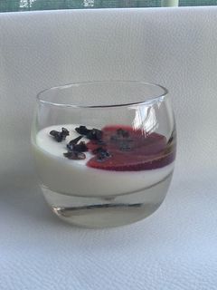 Una foto de Panna Cotta de chocolate blanco con mermelada de frambuesa y aceitunas negras confitadas