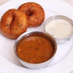 A picture of Vada with coconut chutney and sambhar.