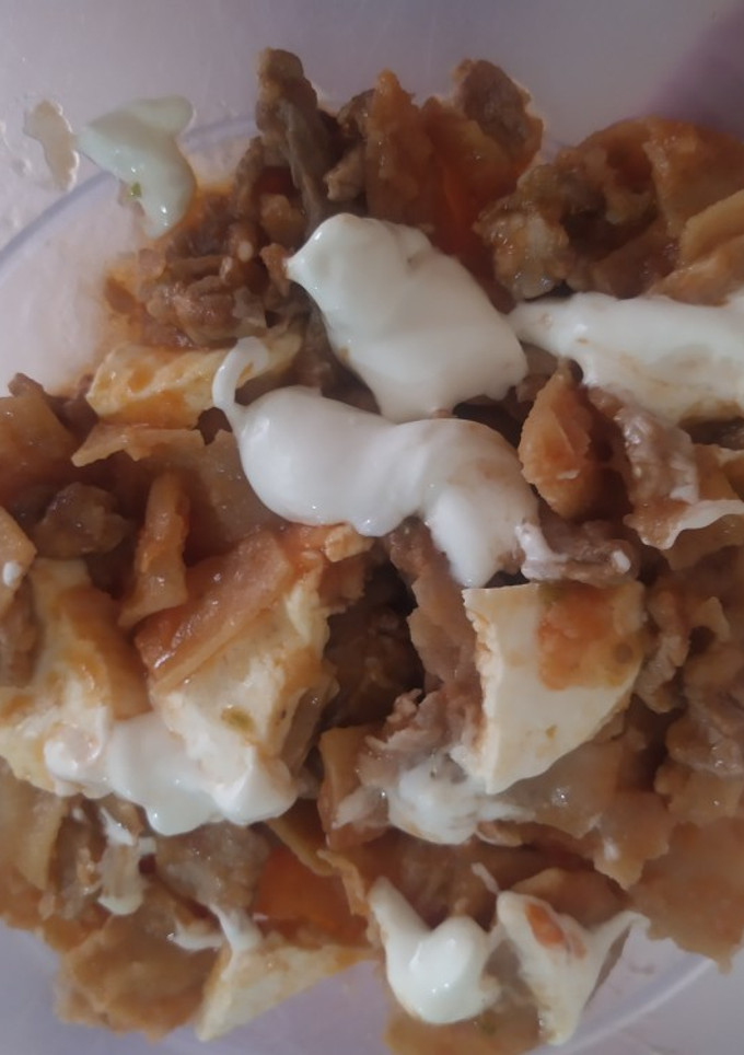 Una foto de Chilaquiles rojos con panela y res