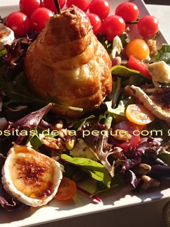 Una foto de Pera en hojaldre con ensalada de roquefort, queso de cabra caramelizado, nueces y pistachos