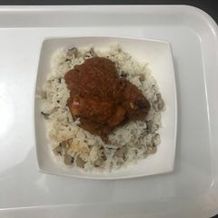 A picture of Chicken Stew Served with Rice and Bean.