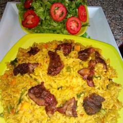 Jollof rice with roasted meat and salad A picture of Jollof rice with roasted meat and salad.