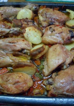 Una foto de Pata muslo y pechugas de pollo con papas sobre colchón de verduras..