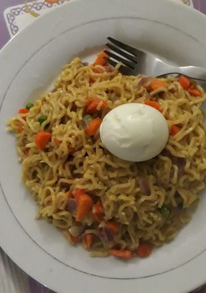 A picture of Indomine and egg with carrots and green peas.